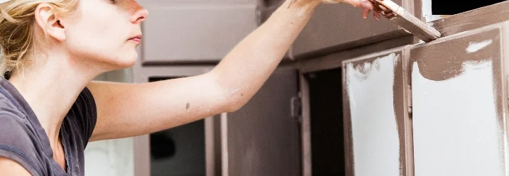 Person streicht Küchenschrank